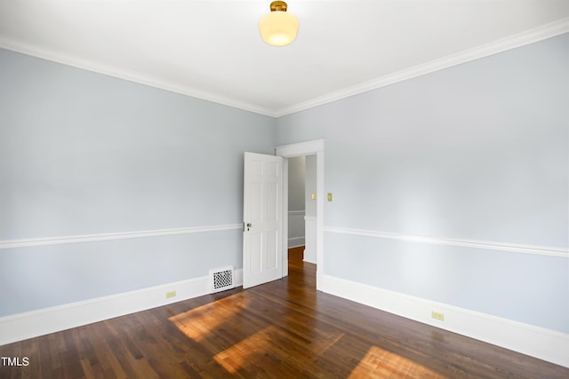 empty room with baseboards, wood finished floors, visible vents, and crown molding