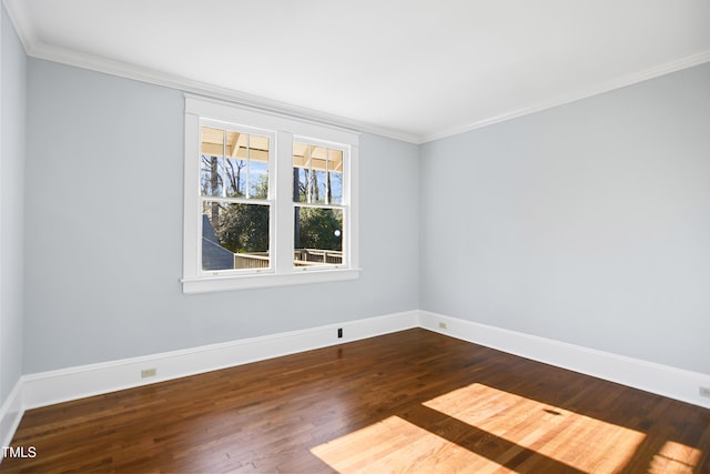 unfurnished room featuring dark wood-style floors, ornamental molding, and baseboards