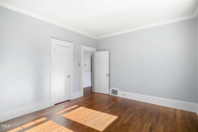 unfurnished room with ornamental molding, wood finished floors, visible vents, and baseboards