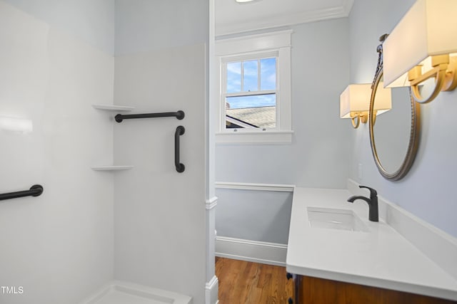 bathroom featuring toilet, a shower, wood finished floors, and vanity