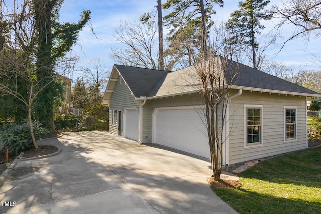 view of side of home with a lawn and a detached garage