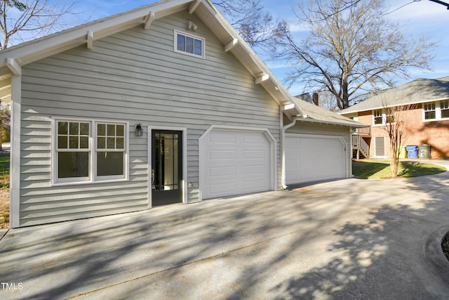 back of house featuring a garage and driveway