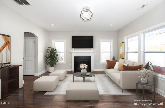 living room with visible vents, arched walkways, and wood finished floors