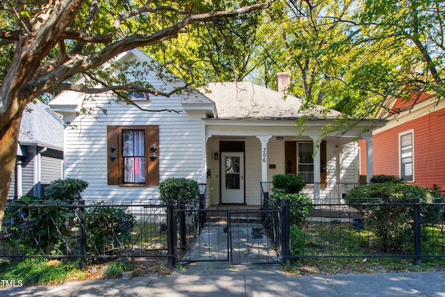 view of front of house featuring a porch, a gate, and a fenced front yard