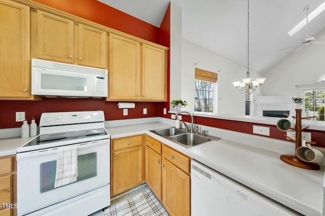 kitchen featuring white appliances, hanging light fixtures, light countertops, a chandelier, and a sink