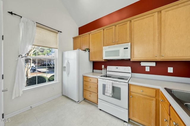 kitchen featuring vaulted ceiling, white appliances, light countertops, and a sink