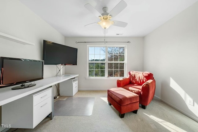 office with light colored carpet, visible vents, baseboards, a ceiling fan, and built in desk