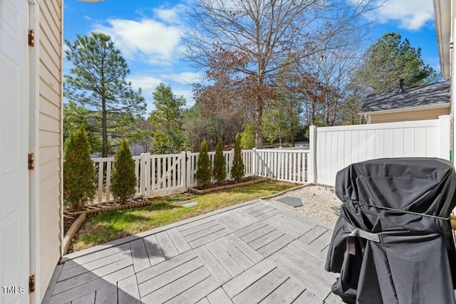 wooden deck featuring a gate, fence, and grilling area