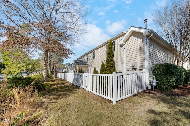 view of side of home featuring a yard and fence