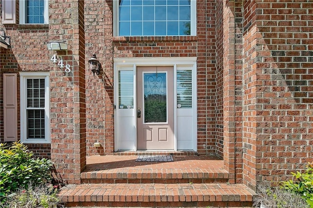 doorway to property with brick siding