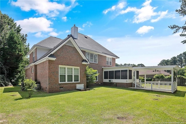 rear view of house with brick siding, a chimney, a lawn, a sunroom, and crawl space