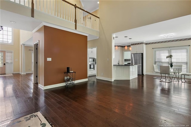 living room with dark wood-style flooring, a healthy amount of sunlight, and baseboards