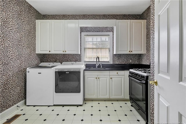 washroom with wallpapered walls, laundry area, visible vents, independent washer and dryer, and a sink