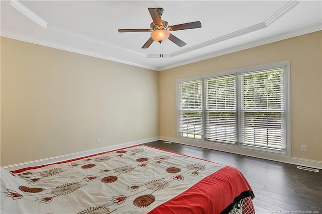 bedroom with ornamental molding, visible vents, baseboards, and wood finished floors