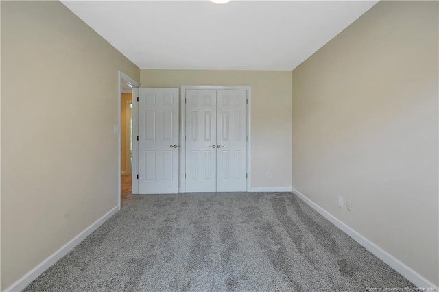 unfurnished bedroom featuring a closet, carpet flooring, and baseboards