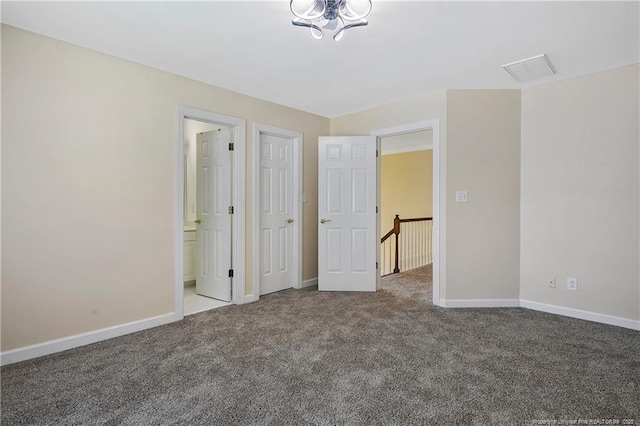 unfurnished bedroom with baseboards, carpet flooring, and ensuite bathroom