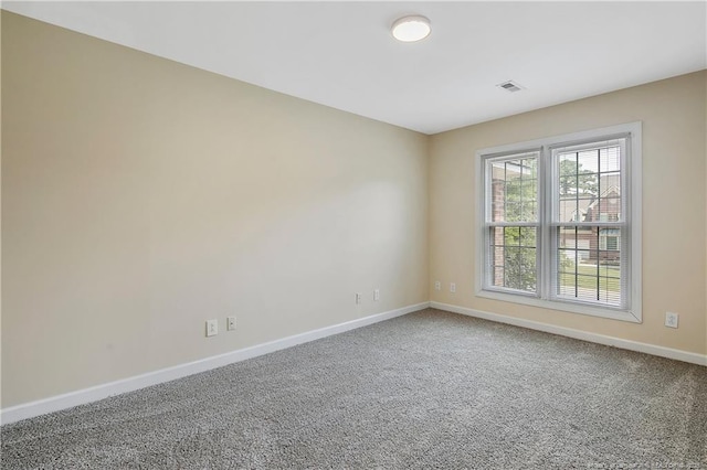 carpeted spare room with visible vents and baseboards