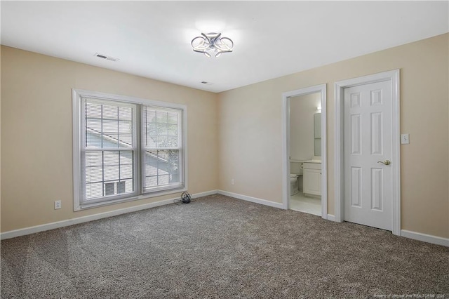 empty room with carpet flooring, visible vents, and baseboards