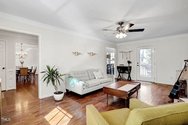 living room with ornamental molding, ceiling fan with notable chandelier, and wood-type flooring