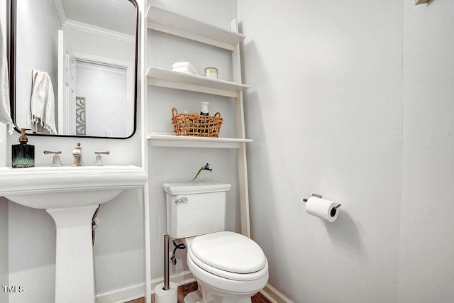 bathroom with toilet, baseboards, and ornamental molding