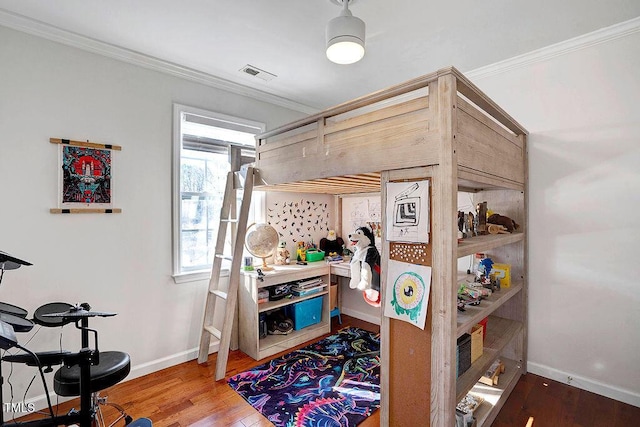 bedroom with visible vents, ornamental molding, and wood finished floors