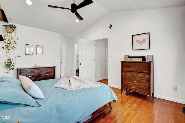 bedroom with baseboards, lofted ceiling, hardwood / wood-style floors, and a ceiling fan