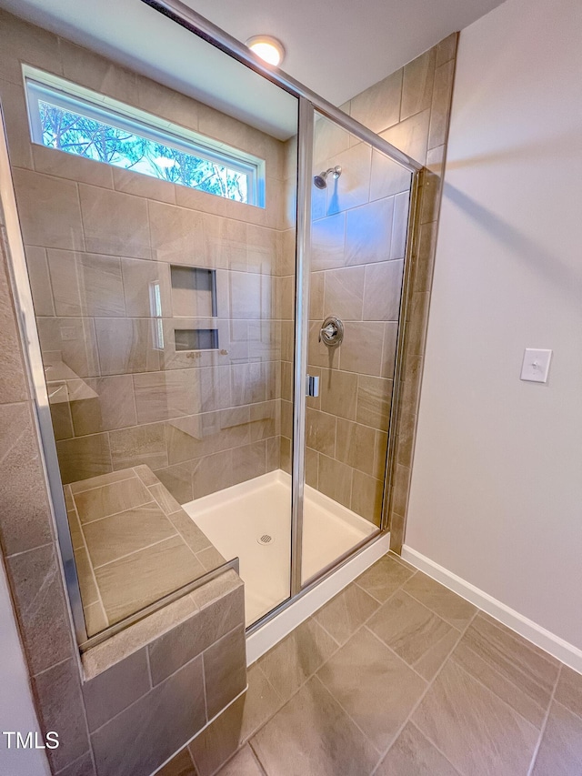 bathroom featuring a stall shower and baseboards