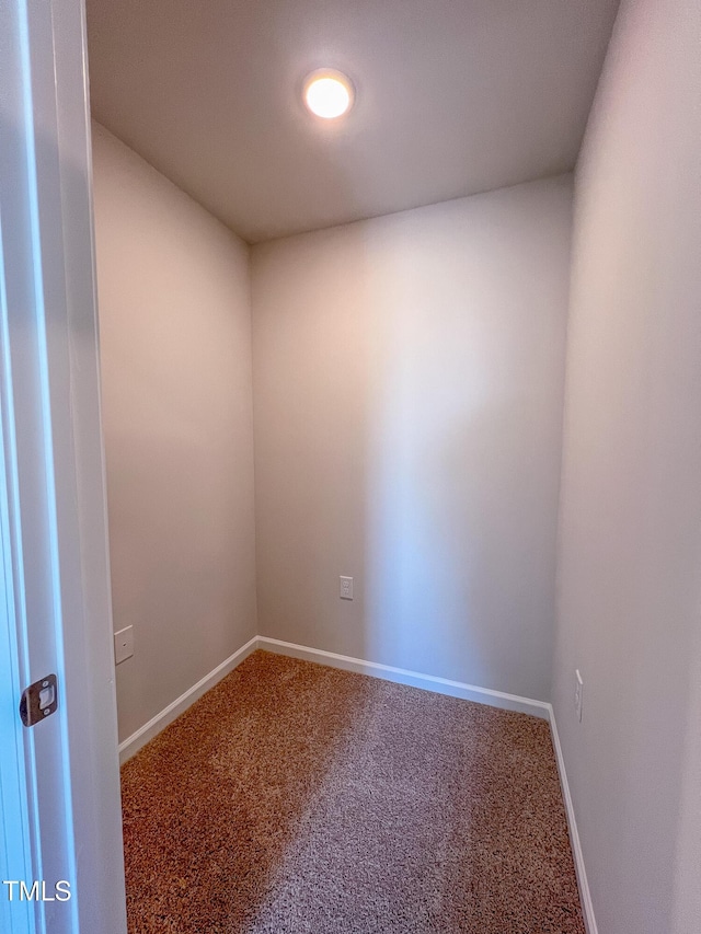 carpeted empty room featuring baseboards