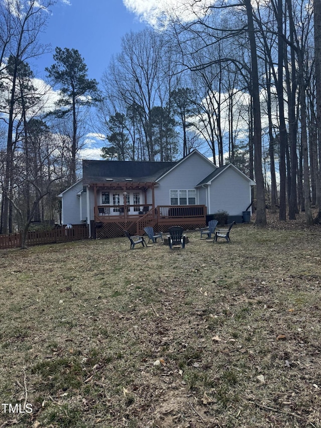 view of front of property with an outdoor fire pit, fence, a front lawn, and a deck