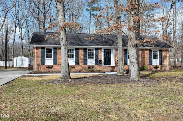 single story home featuring crawl space, a front lawn, an outbuilding, and brick siding