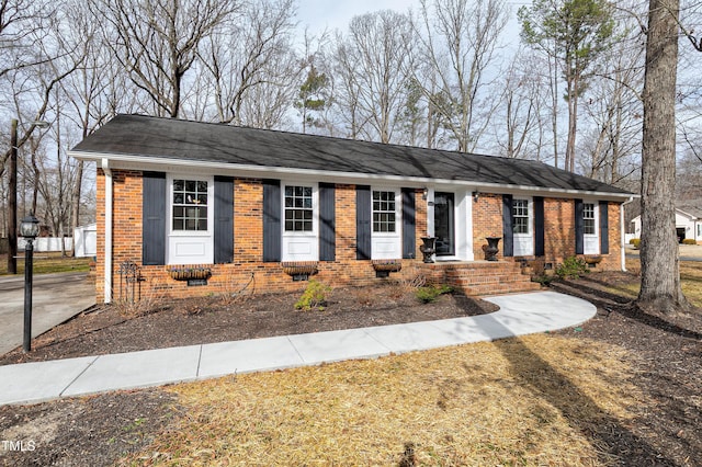 single story home featuring crawl space, brick siding, and a shingled roof