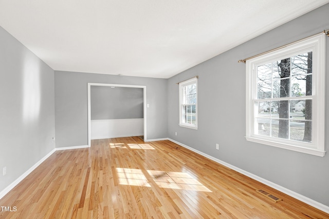 spare room featuring baseboards, visible vents, and light wood-type flooring