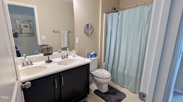 full bath with double vanity, a sink, toilet, and tile patterned floors