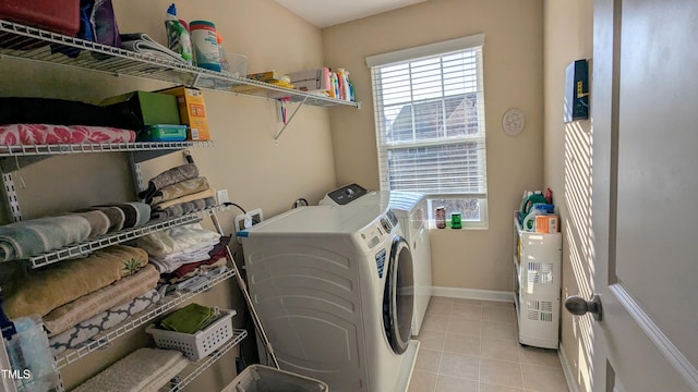 laundry room with laundry area, light tile patterned flooring, baseboards, and separate washer and dryer