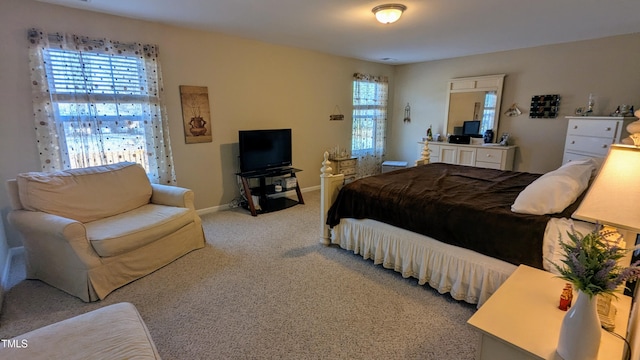 bedroom featuring light carpet and baseboards