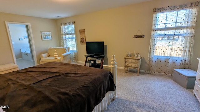 carpeted bedroom featuring connected bathroom and baseboards