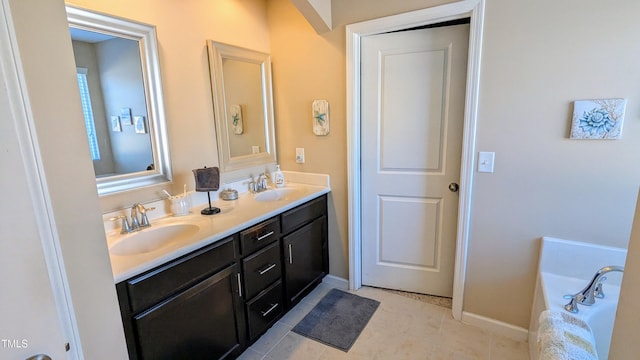 full bathroom with double vanity, a sink, a tub, and baseboards