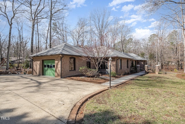 view of front of home with a garage, driveway, brick siding, and a front yard