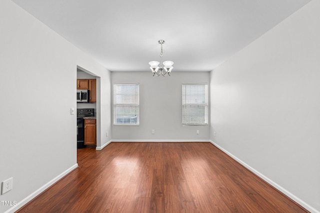 unfurnished dining area featuring baseboards, a chandelier, and dark wood-style flooring