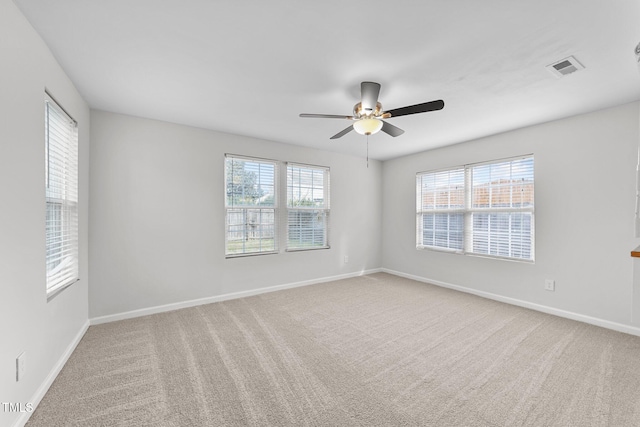 unfurnished room with carpet floors, a wealth of natural light, and visible vents