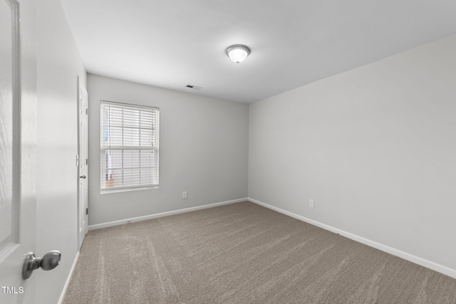 carpeted empty room featuring visible vents and baseboards