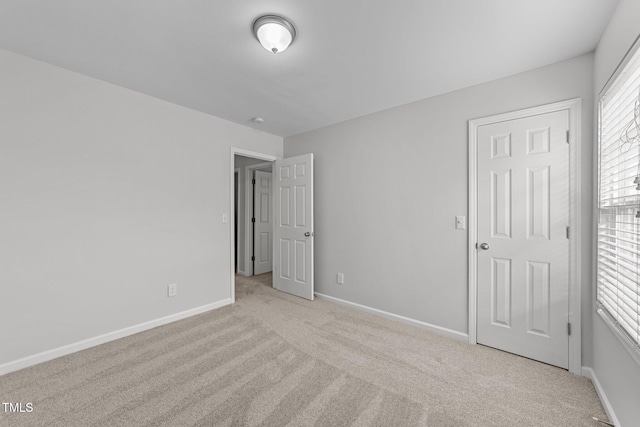 unfurnished bedroom with carpet flooring and baseboards