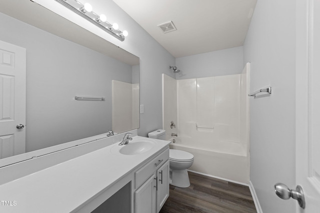 bathroom with toilet, wood finished floors, visible vents, vanity, and shower / washtub combination