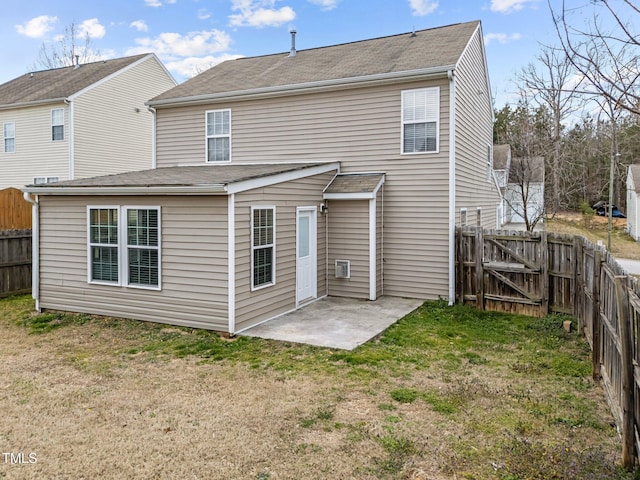 back of house with a yard, a patio area, a fenced backyard, and a gate