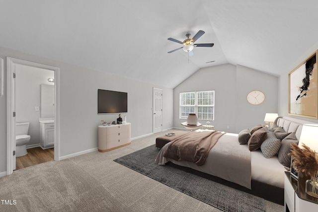 bedroom with carpet, a ceiling fan, connected bathroom, vaulted ceiling, and baseboards