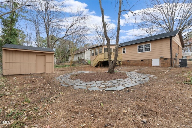 view of yard with an outbuilding, central AC, fence, stairway, and a storage unit