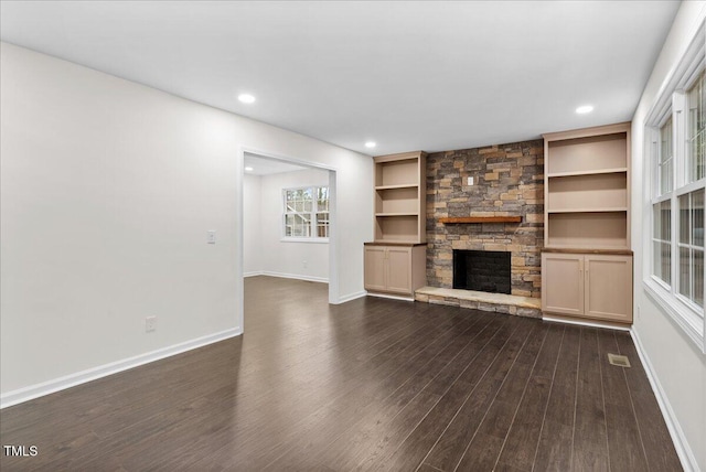 unfurnished living room featuring dark wood-style floors, recessed lighting, a fireplace, and baseboards