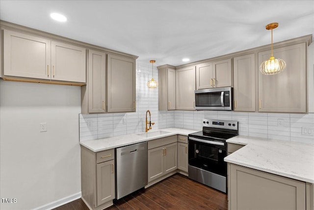 kitchen featuring dark wood-style floors, light stone countertops, stainless steel appliances, gray cabinetry, and a sink