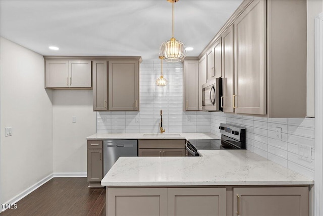 kitchen with stainless steel appliances, dark wood-style flooring, a sink, baseboards, and tasteful backsplash