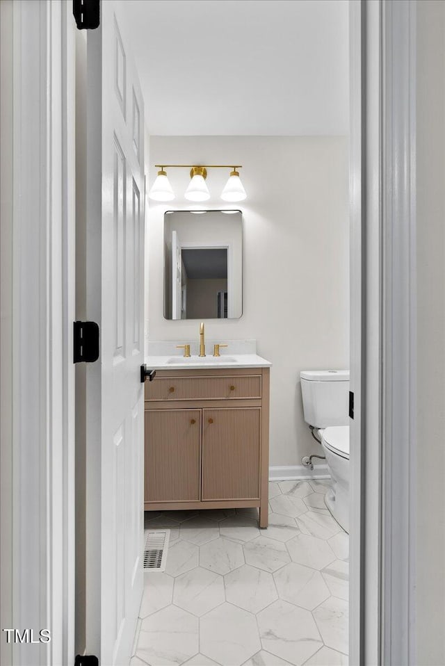 bathroom featuring toilet, marble finish floor, visible vents, and vanity